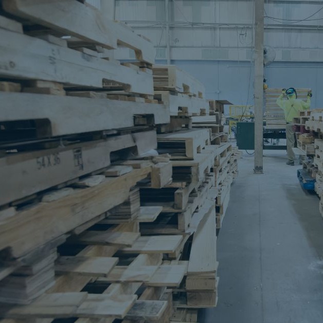 stack of pallets with worker in background