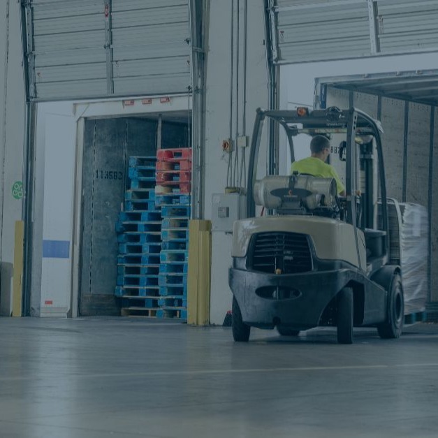 Forklift operator transporting pallets in a warehouse, showcasing Relogistics' tailored solutions for inventory management and operational efficiency.