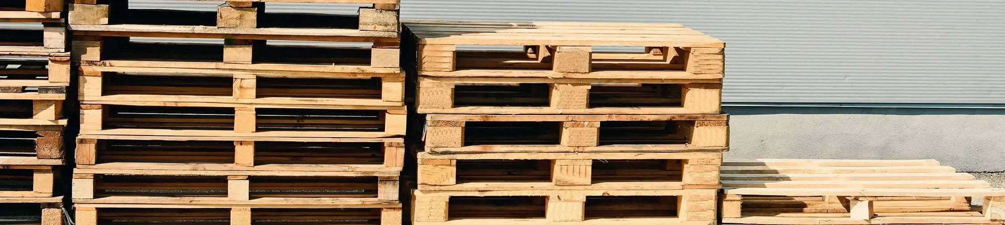 Stacks of wooden pallets in a distribution center, showcasing high-quality pallet supply for efficient supply chain management. Stacks of wooden pallets in a distribution center, showcasing high-quality pallet supply for efficient supply chain management.