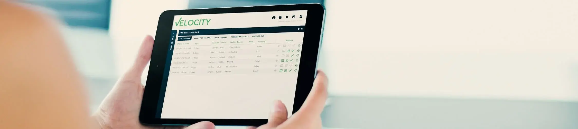 Person holding a tablet displaying the Velocity software interface for logistics management, emphasizing supply chain efficiency and data tracking. Person holding a tablet displaying the Velocity software interface for logistics management, emphasizing supply chain efficiency and data tracking.
